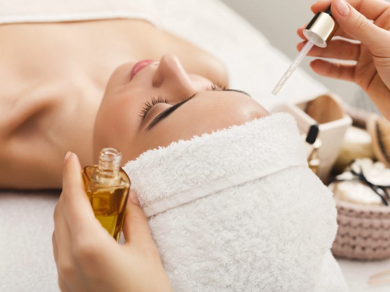 Facial massage. Spa, resort, beauty and health concept. Beautiful woman getting professional face treatment with nourishing organic oil, copy space